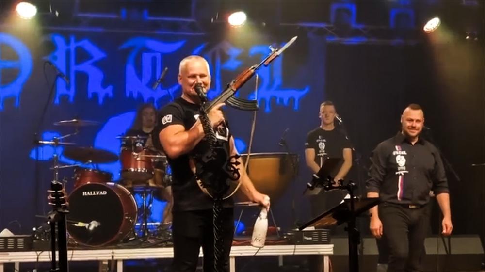 Odsouzený vrah Kajínek se samopalem v ruce křtí nové album xenofobní skupině Ortel