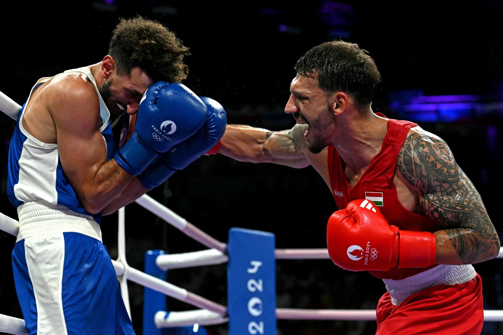 Maďarský boxer Richárd Kovács (v červeném) v souboji s Francouzem Sofiane Oumiha ve čtvrtfinále boxerského zápasu ve váze do 63,5 kg během Olympijských her 2024 v Paříži v North Paris Areně ve Villepinte 1. srpna 2024. (FOTO: MOHD RASFAN / AFP / AFP / Profimedia)