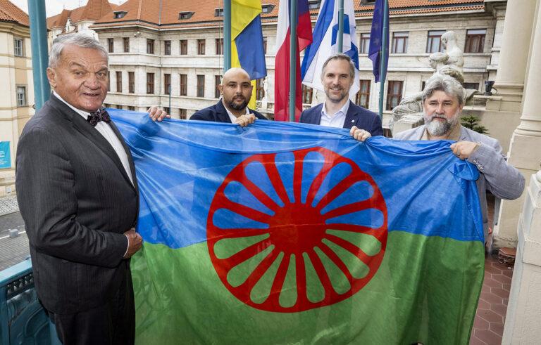 Vyvěšení romské vlajky na budově Magistrátu hlavního města Prahy. Zleva: primátor Bohuslav Svoboda, ředitel organizace RomanoNet Michal Miko, první náměstek primátora Zdeněk a radní hlavního města Prahy Michal Hroza, 2. 8. 2024 (FOTO: se svolením Magistrátu hlavního města Prahy)