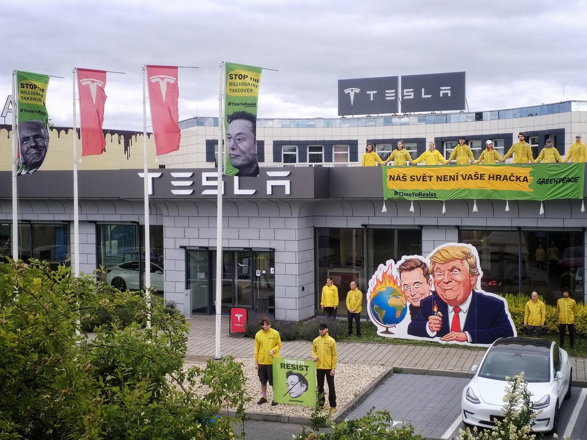 Aktivisté z organizace Greenpeace protestují 11. června 2025 ráno na střeše zákaznického centra společnosti Tesla v Čestlicích u Prahy. Akcí chtějí upozornit na podle nich nebezpečné počínání amerického prezidenta Donalda Trumpa a podnikatele Elona Muska. (FOTO: Petr Zewlakk Vrabec)